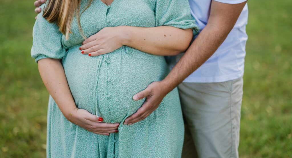 Handen op zwangere buik tijdens ouderschapsverlof